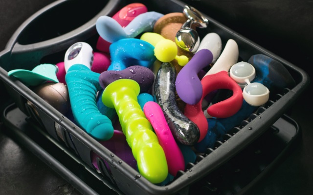many colorful sex toys in a black bin