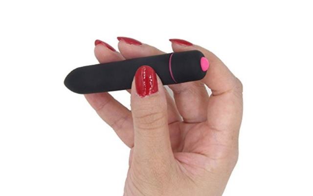 Black and pink bullet vibrator held in fingertips of a woman