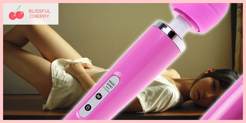Woman lying on the floor with pink wand vibrator in foreground