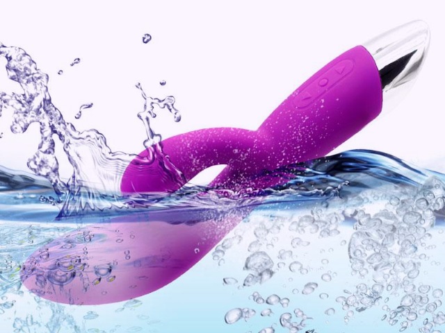 A purple vibrator being submerged into water