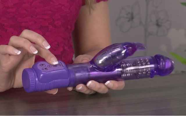 Purple rabbit vibrator being held by a woman at a table